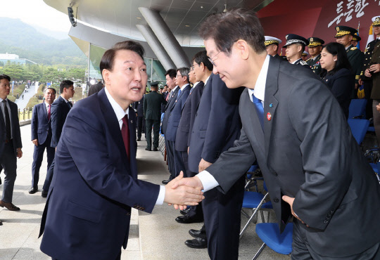 윤석열 대통령이 지난 1일  충남 계룡대 대연병장에서 열린 건군 '제74주년 국군의 날' 기념식에 참석한 뒤 더불어민주당 이재명 대표와 악수하고 있다. <연합뉴스>